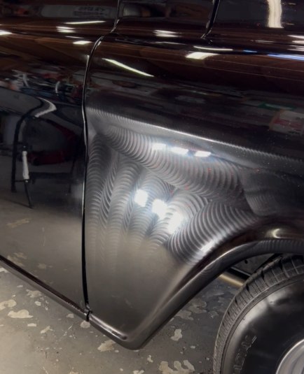 Swirl marks and holograms showing across a dark truck panel under direct light