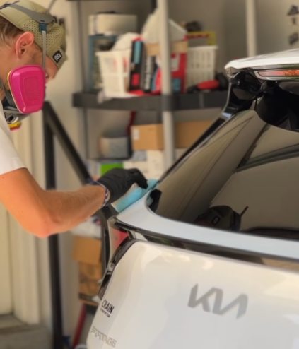 Applying ceramic coating to the rear hatch of a white Kia