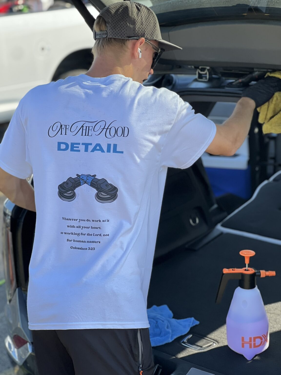 Off The Hood detailer in a branded shirt working out of the back of a vehicle